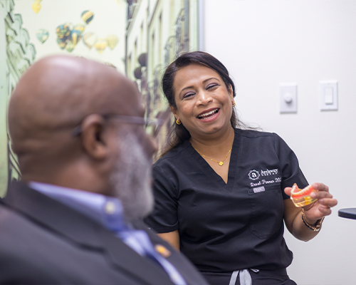 Dentist showing model of teeth to dental patient