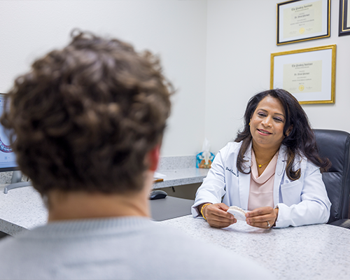 Female dentist talking to patient at desk