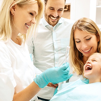 Young girl in dental chair with her mother.