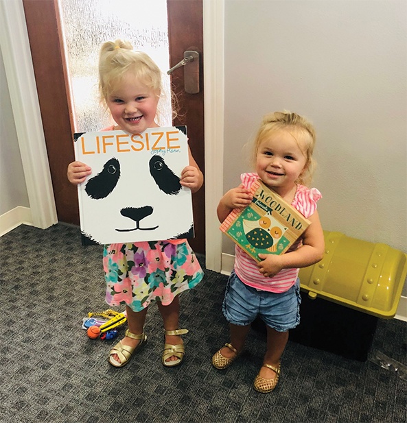 Two kids holding books