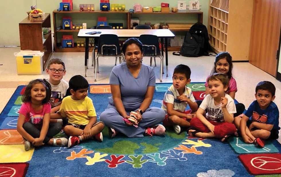 Dr Parmar with group of kids in classroom