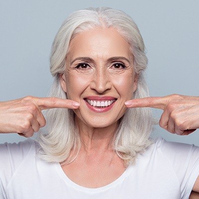 Older woman pointing to flawless smile