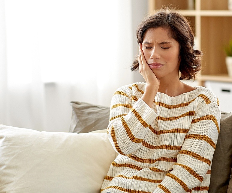 Woman with a toothache in McKinney holding her cheek