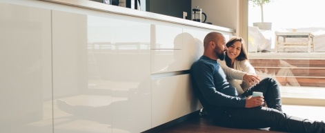 Man and woman sitting on their kitchen floor