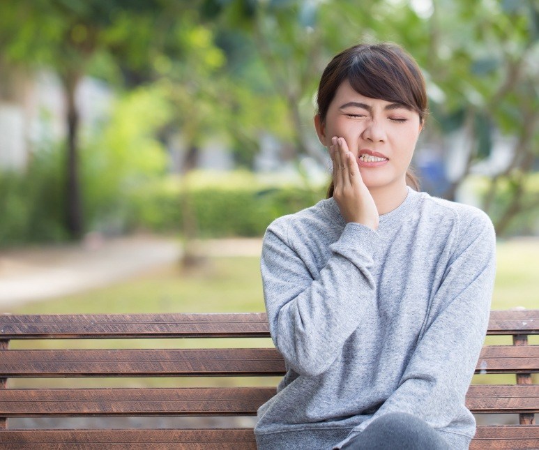 Woman in pain holding cheek