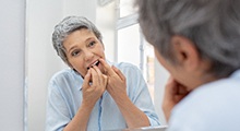 Woman practicing dental implant care in McKinney by flossing