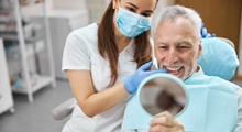 older man smiling after getting dental implants in McKinney