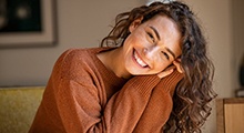 Woman leaning forward and smiling brightly