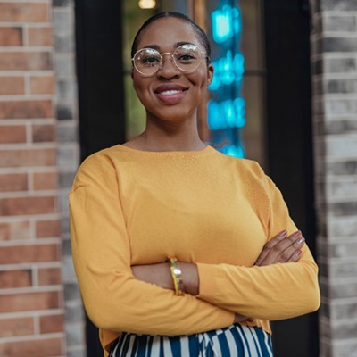 person smiling with their arms crossed