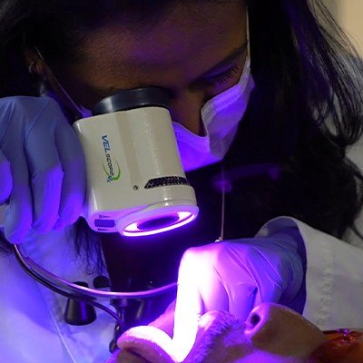 Dentist performing oral cancer screening