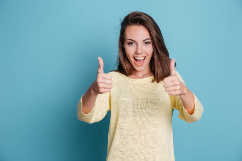 woman smiling and giving thumbs up