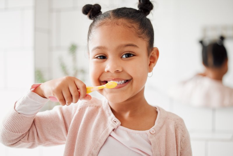 young girl brushing her teeth